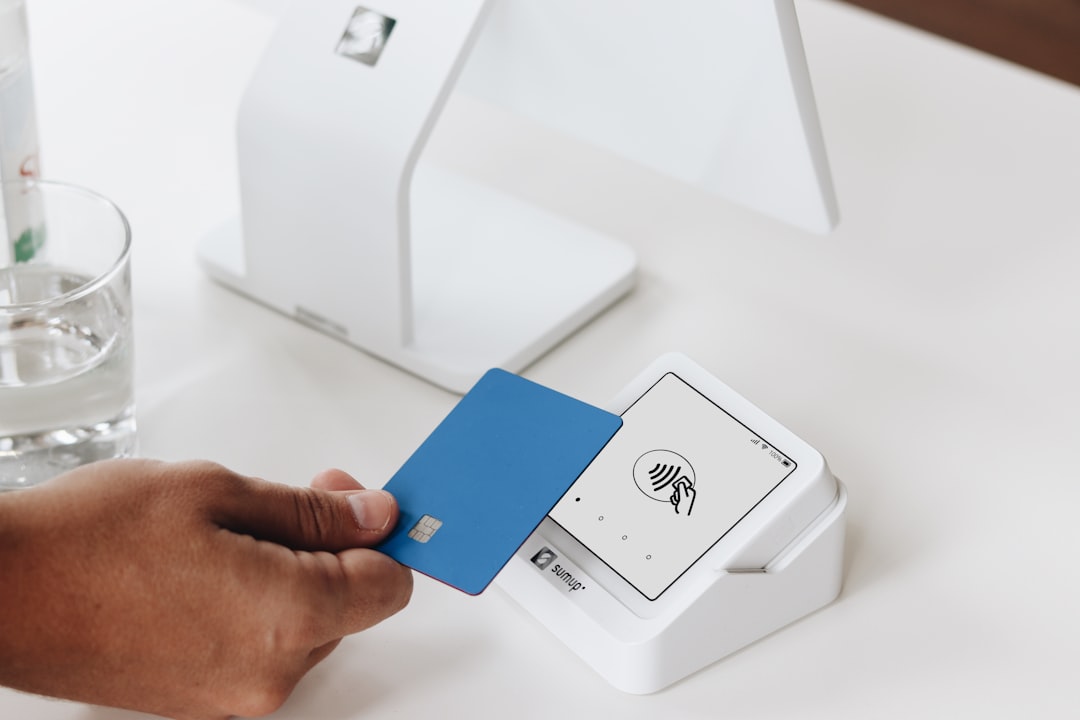 services-02 A close-up of a customer making a contactless payment with a blue card using the SumUp Solo card reader. In the background, a larger point of sale (POS) system is visible, emphasizing the versatility and modern design of SumUps payment solutions. The scene reflects a sleek and efficient checkout process ideal for small businesses, beauty salons, cafes, or retail environments.